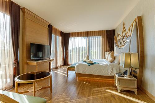 ノンタブリーにあるW1Bangkoknoi Hotelのベッドとテレビがあるホテルの部屋
