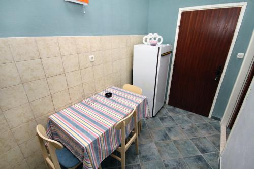 een keuken met een tafel en een koelkast bij Apartments by the sea Pisak, Omis - 1070 in Mimice