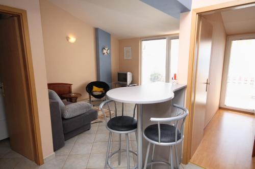 a living room with a table and two stools at Apartments by the sea Pisak, Omis - 1070 in Mimice