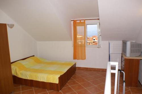 een kleine slaapkamer met een bed en een raam bij Holiday apartments Slatine, Ciovo - 4289 in Slatine