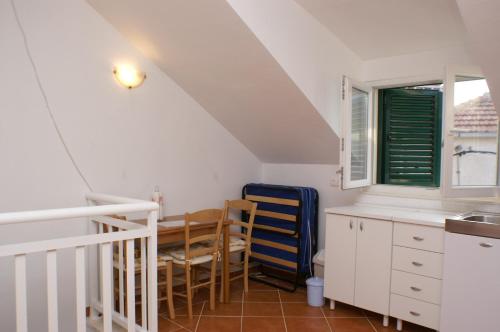 een keuken met een tafel en stoelen en een wastafel bij Holiday apartments Slatine, Ciovo - 4289 in Slatine