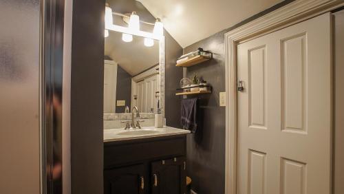 a bathroom with a sink and a mirror at 160inch Home Movie Theater- Great for movie night! in Omaha