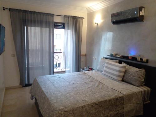 Un dormitorio con una cama grande y una ventana en Appartment Jnane Atlas, en Marrakech