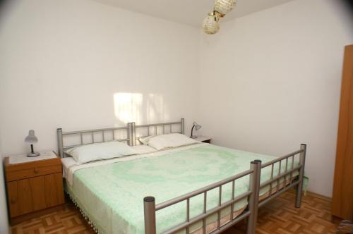 Vrbanj的住宿－Apartments by the sea Mudri Dolac, Hvar - 4042，一间卧室配有一张带绿床罩和灯的床。