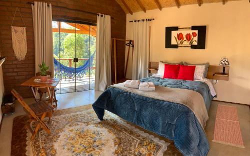 1 dormitorio con 1 cama grande con almohadas rojas en Chalés Água azul, en Santo Antônio do Pinhal