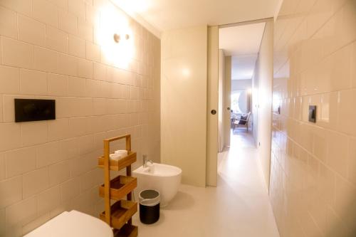 a white bathroom with a toilet and a sink at Alegria Suítes By Porto City Hosts in Porto