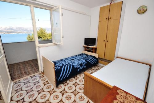 Habitación pequeña con cama y ventana en Apartments by the sea Arbanija, Ciovo - 1085 en Trogir