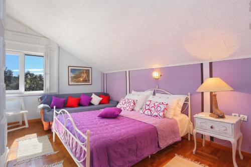 - une chambre violette avec un lit et un canapé dans l'établissement Apartments by the sea Kanica, Rogoznica - 1106, à Rogoznica
