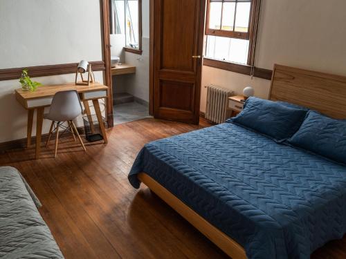 a bedroom with a bed and a desk and a table at Planta Alta Bed & Breakfast in Buenos Aires