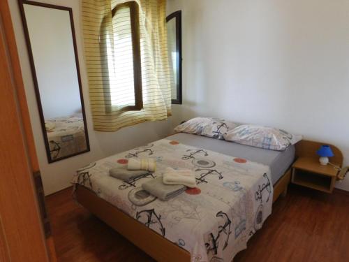 a small bedroom with a bed and a window at Apartment Slatine 1128a in Slatine