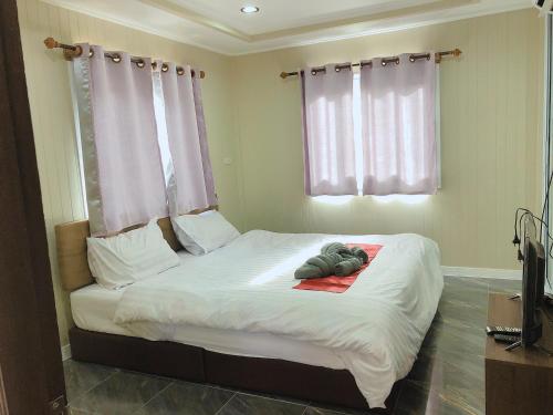 - une chambre avec un lit doté de draps blancs et une fenêtre dans l'établissement Sukanya Guesthouse, 