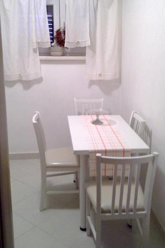 a white dining room table with two chairs and a white table at Apartments by the sea Kolocep, Elafiti - 2182 in Koločep