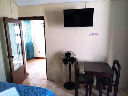 a room with a table and a television on the wall at El Ático Guatemala in Guatemala