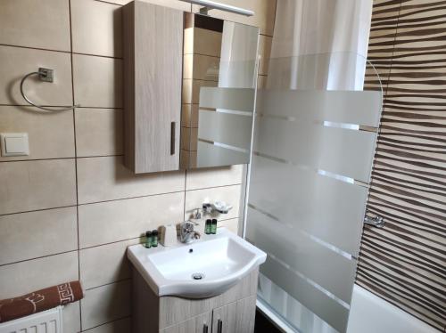 W łazience znajduje się umywalka i lustro. w obiekcie AVELLANA ROYAL SUITES w mieście Leptokaria