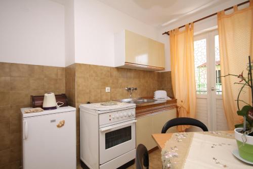 cocina con fogones blancos horno superior junto a una mesa en Apartments with a parking space Hvar - 4004, en Hvar