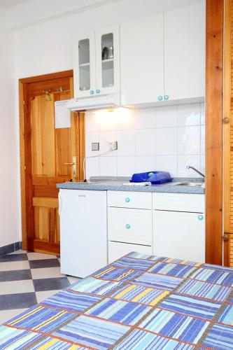 a kitchen with white cabinets and a checkered floor at Apartments by the sea Sucuraj, Hvar - 3589 in Sućuraj