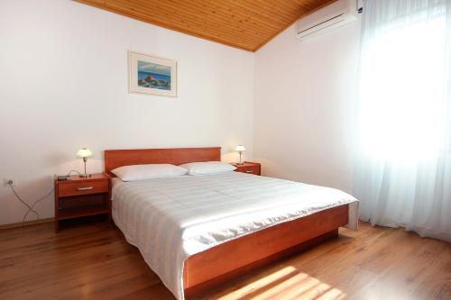 a bedroom with a large bed and a window at Apartments and rooms by the sea Mandre, Pag - 3557 in Kolan