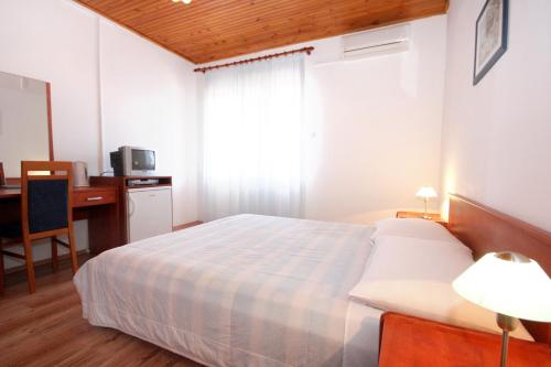 a bedroom with a bed and a desk and a window at Double Room Mandre 3557b in Kolan