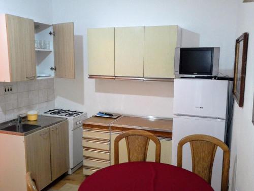 uma pequena cozinha com um frigorífico branco e um micro-ondas em Apartment Zubovici 4125d em Zubovići