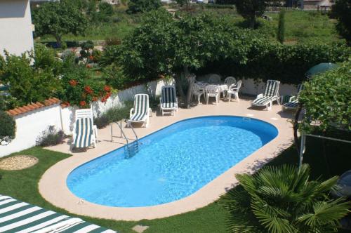- une vue sur la piscine entourée de chaises longues dans l'établissement Family friendly apartments with a swimming pool Vodice - 4235, à Vodice