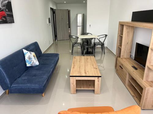 ein Wohnzimmer mit einem blauen Sofa und einem Tisch in der Unterkunft Tarrafal Guest House in Tarrafal