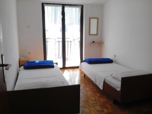 a room with two beds with blue pillows on them at Apartments by the sea Sepurine, Prvic - 4238 in Prvić Šepurine