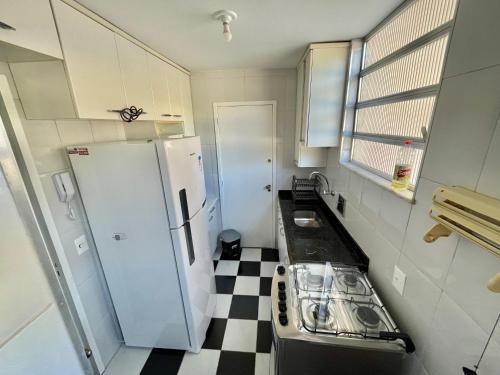 a small kitchen with a refrigerator and a checkered floor at Apto novo em Icarai in Niterói