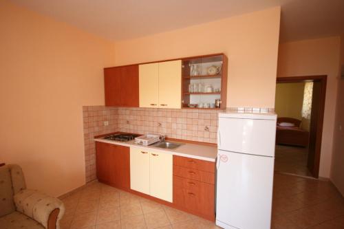 a kitchen with a sink and a white refrigerator at Apartments by the sea Kustici, Pag - 4081 in Zubovići