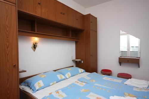 a bedroom with a bed with a wooden head board at Apartments and rooms by the sea Supetarska Draga - Donja, Rab - 2001 in Rab