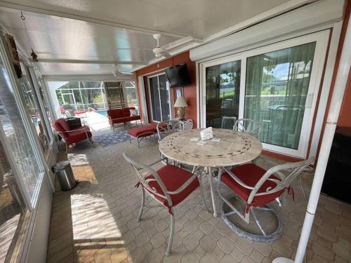 a patio with a table and chairs on a balcony at Heated Pool Paradise, Gulf Access, Pet Friendly in Port Charlotte