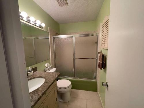 a bathroom with a shower and a toilet and a sink at Heated Pool Paradise, Gulf Access, Pet Friendly in Port Charlotte