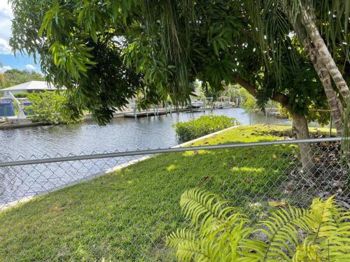 a chain link fence with a river behind it at Heated Pool Paradise, Gulf Access, Pet Friendly in Port Charlotte