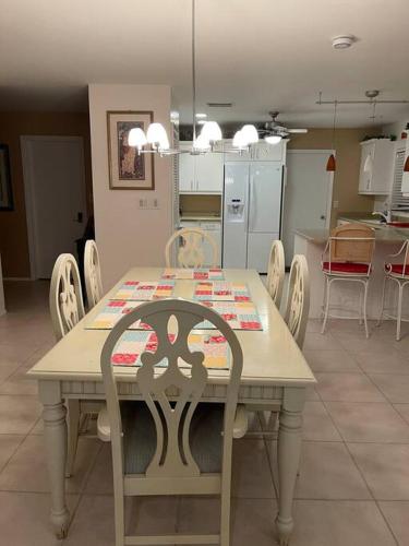 a dining room table with chairs and a kitchen at Heated Pool Paradise, Gulf Access, Pet Friendly in Port Charlotte