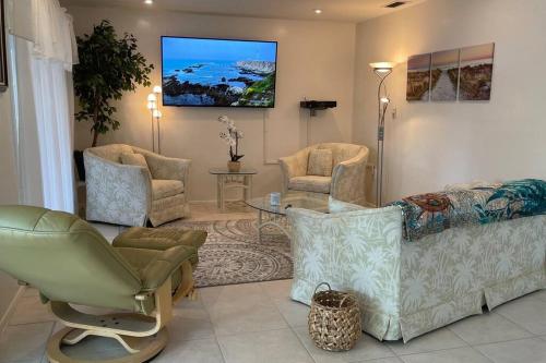 a living room with a couch and chairs and a tv at Heated Pool Paradise, Gulf Access, Pet Friendly in Port Charlotte