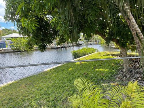a chain link fence with a river behind it at Heated Pool Paradise, Gulf Access, Pet Friendly in Port Charlotte