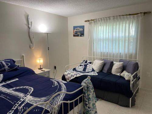 a bedroom with two beds and a couch in it at Heated Pool Paradise, Gulf Access, Pet Friendly in Port Charlotte