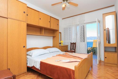 a bedroom with a large bed and a large window at Apartments with a parking space Slatine, Ciovo - 2030 in Trogir