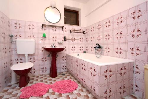 a pink bathroom with a tub and a sink at Apartments by the sea Slatine, Ciovo - 2039 in Slatine