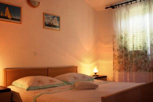 a bedroom with a bed with two pillows and a window at Seaside holiday house Cove Zarace - Gdinj, Hvar - 2048 in Gdinj