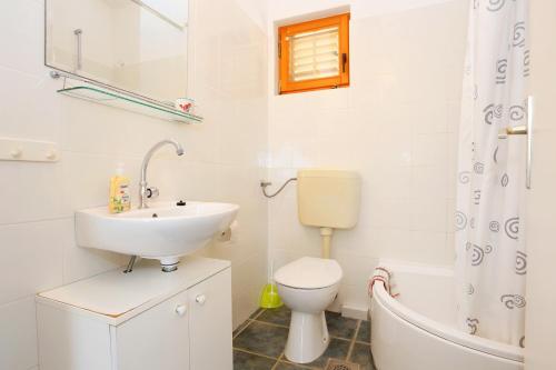 a bathroom with a sink and a toilet and a bath tub at Apartments by the sea Sevid, Trogir - 2044 in Sevid