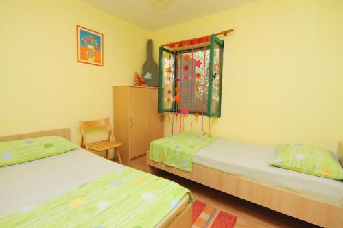 1 Schlafzimmer mit 2 Betten, einem Fenster und einem Stuhl in der Unterkunft Seaside house for families with children Cove Tvrdni Dolac, Hvar - 2057 in Gdinj