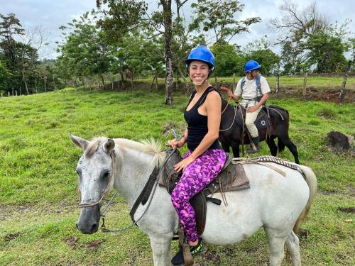 una mujer está sentada sobre un caballo blanco en Cabañas Don Ramiro en Colonia Dos Ríos