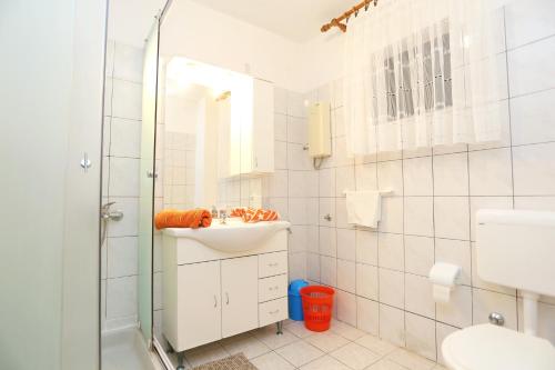 ein weißes Badezimmer mit Waschbecken und Dusche in der Unterkunft Apartments by the sea Okrug Gornji, Ciovo - 1069 in Trogir