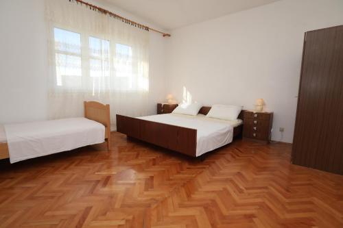 sypialnia z 2 łóżkami i drewnianą podłogą w obiekcie Apartment Vinisce 1165b w mieście Vinišće