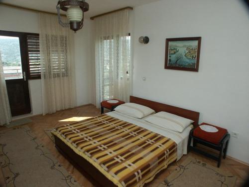 a bedroom with a bed and two chairs and a window at Apartments with a parking space Marina, Trogir - 2036 in Marina