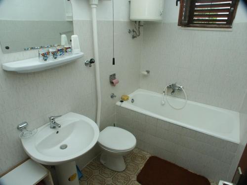a bathroom with a sink and a toilet and a tub at Apartments with a parking space Marina, Trogir - 2036 in Marina