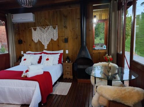 a bedroom with two beds and a glass table at CABANA PARAÍSO in Santo Amaro da Imperatriz