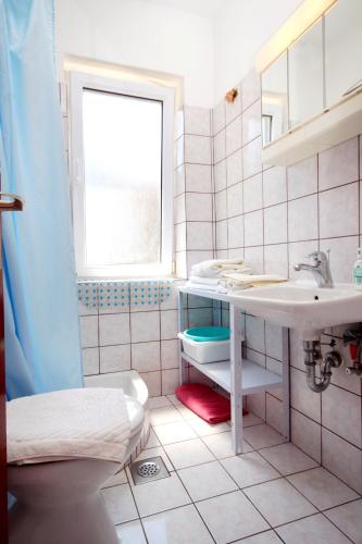 a bathroom with a sink and a toilet and a window at Apartments and rooms with a swimming pool Slano, Dubrovnik - 2179 in Slano