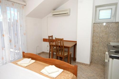 a bedroom with a bed and a table and a kitchen at Apartments and rooms with parking space Slano, Dubrovnik - 2159 in Slano