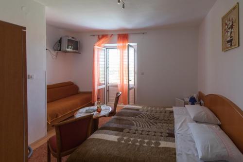 a bedroom with a bed and a couch and a window at Rooms with WiFi Lopud, Elafiti - 2169 in Lopud Island